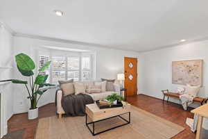 Living area featuring baseboards, ornamental molding, dark wood finished floors, and recessed lighting