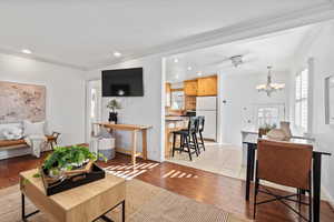 Living room with light wood-type flooring, crown molding, and recessed lighting