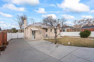 Exterior of home with new concrete, fencing, & a beautiful yard