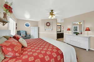 Carpeted bedroom featuring connected bathroom and baseboards