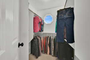 Walk in closet featuring light colored carpet