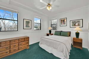 Bedroom with a ceiling fan, dark carpet, and baseboards