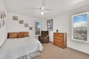 Bedroom featuring light colored carpet, ceiling fan, and baseboards