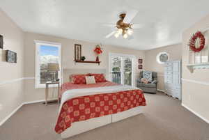 Carpeted bedroom featuring a ceiling fan and baseboards