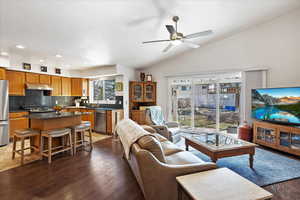 Living area featuring dark wood finished floors, a ceiling fan, lofted ceiling, a textured ceiling, and recessed lighting