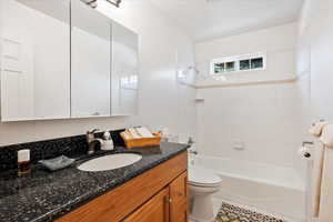 Full bath featuring toilet, vanity, washtub / shower combination, and tile patterned floors