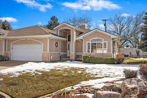 View of front of home featuring a garage, concrete driveway, a chimney, and stucco siding