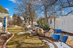 View of yard with fence and a pergola