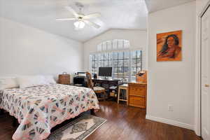 Bedroom featuring lofted ceiling, dark wood-style flooring, a ceiling fan, and baseboards