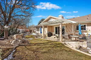 Back of property featuring stucco siding, a chimney, a pergola, and a patio