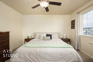 Carpeted bedroom featuring ceiling fan