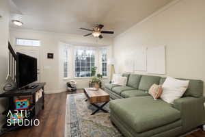 Living room with dark wood-type flooring, a wealth of natural light, and crown molding