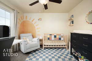 Carpeted bedroom featuring a ceiling fan