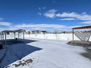 Snowy yard featuring a fenced backyard