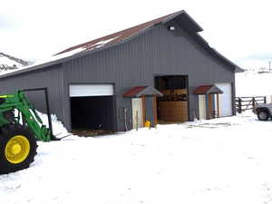 Snow covered garage with a garage