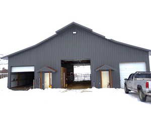 Snow covered garage with a detached garage