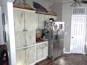 Kitchen with a ceiling fan, visible vents, dark wood-style flooring, and stainless steel fridge with ice dispenser