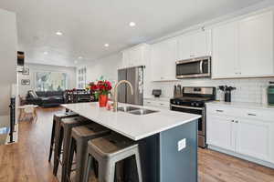 Kitchen with an island with sink, appliances with stainless steel finishes, light countertops, and open floor plan