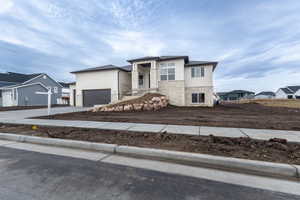 View of front of property with a garage, a residential view, stone siding, and driveway