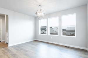 Unfurnished room with light wood-type flooring, baseboards, and visible vents