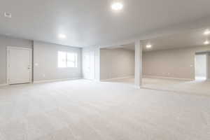 Below grade area featuring recessed lighting, visible vents, baseboards, and light colored carpet