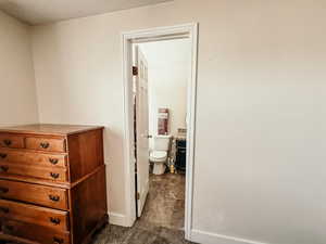 Hall with dark carpet and baseboards