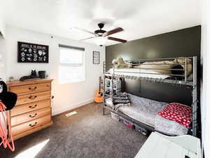 Bedroom featuring ceiling fan, baseboards, and dark colored carpet