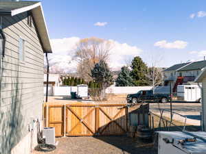 View of yard featuring cooling unit, a gate, fence, and a mountain view