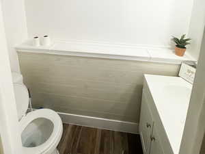 Bathroom with a textured ceiling, wood finished floors, vanity, and visible vents