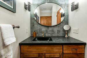 Bathroom featuring vanity and decorative backsplash