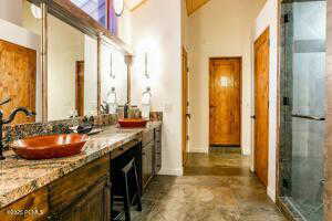 Bathroom with an enclosed shower, vanity, and a towering ceiling