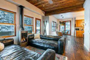 Living room featuring ceiling fan, dark hardwood / wood-style flooring, and wood ceiling