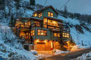 Snow covered property with a garage and a balcony