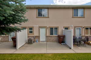 Rear view of house with a patio, brick siding, and stucco siding