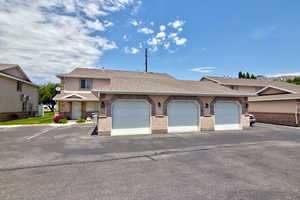 Townhome / multi-family property with roof with shingles and brick siding