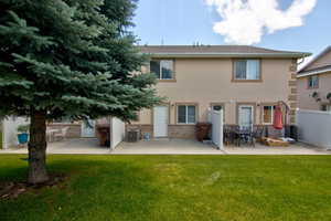 Rear view of property featuring a patio area, brick siding, and stucco siding