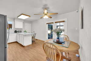 Dining area with light wood-type flooring ceiling fan and french doors to the covered trex deck