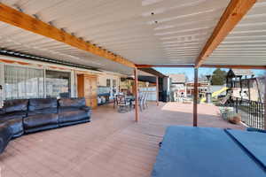 Wooden terrace with outdoor dining area and a playground