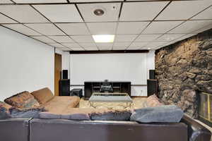 Cinema with a paneled ceiling and a fireplace