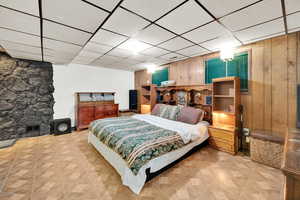 Bedroom featuring visible vents, wood walls, and a paneled ceiling