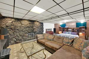 Living room with a paneled ceiling and a stone fireplace