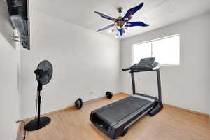 Workout room featuring wood finished floors and baseboards