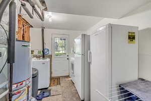 Washroom featuring washer and dryer, water softener