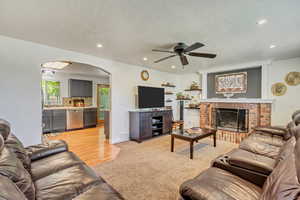 Living area with a brick fireplace, arched walkways, and recessed lighting