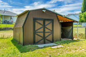 View of shed featuring fence