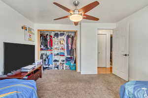 Bedroom featuring carpet floors, a closet, baseboards, and a ceiling fan