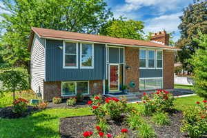 Bi-level home featuring a chimney and brick siding