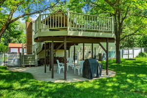 Rear view of house featuring stairway, a yard, fence, a wooden deck, and a patio area