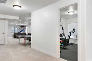 Exercise room featuring light carpet, recessed lighting, visible vents, and baseboards