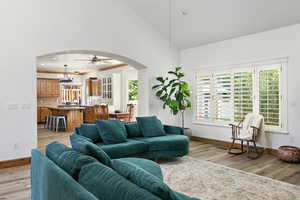 Living room featuring light wood-style flooring, arched walkways, and baseboards